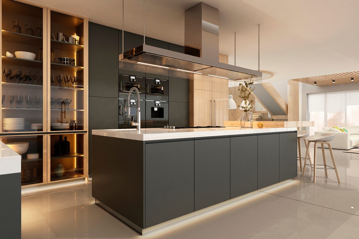 A modern kitchen with a long charcoal island, a white benchtop, a stainless rangehood and lit timber shelving